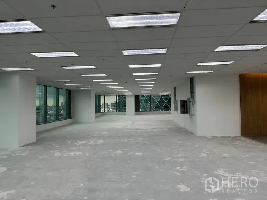 Office Space for rent in Ratchathewi, Bangkok - Spacious office level with suspended ceiling lights, wall-to-wall glazing and wood panel near lift lobby.