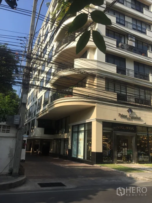 Condominium for rent or sale in Watthana, Bangkok - Mid-rise condominium exterior with curved balconies and street-level retail.
