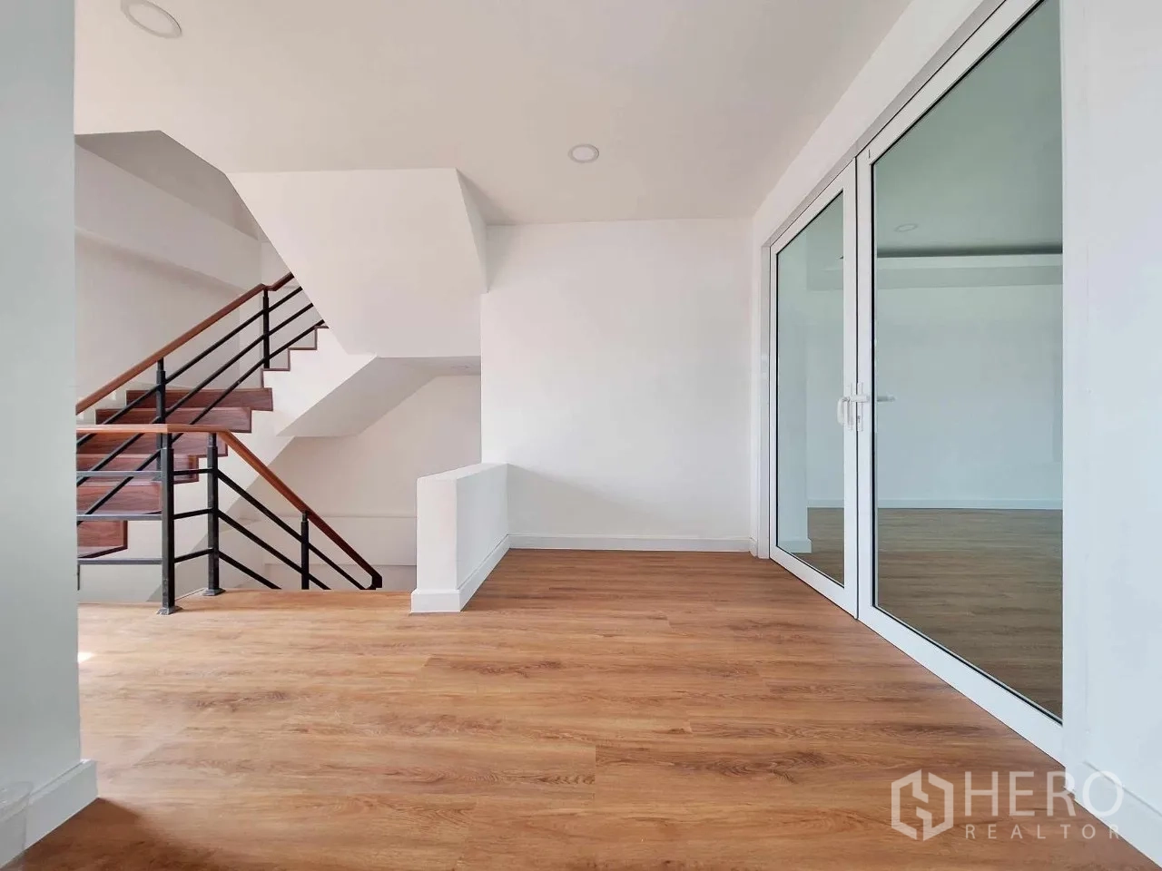 Home Office for sale in Bueng Kum, Bangkok - Hallway by the staircase with glass doors leading to a large office room.