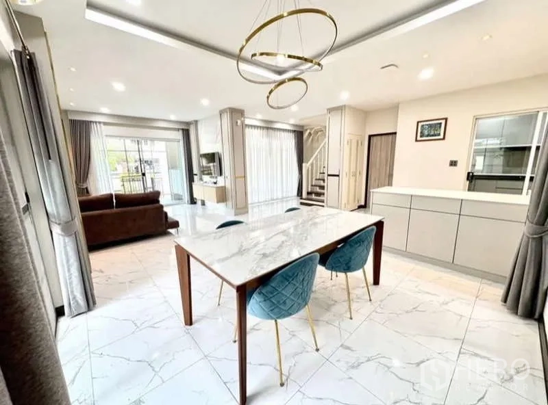 Detached House for rent in Phasi Charoen, Bangkok - Dining space with marble table, designer chandelier and view to kitchen.