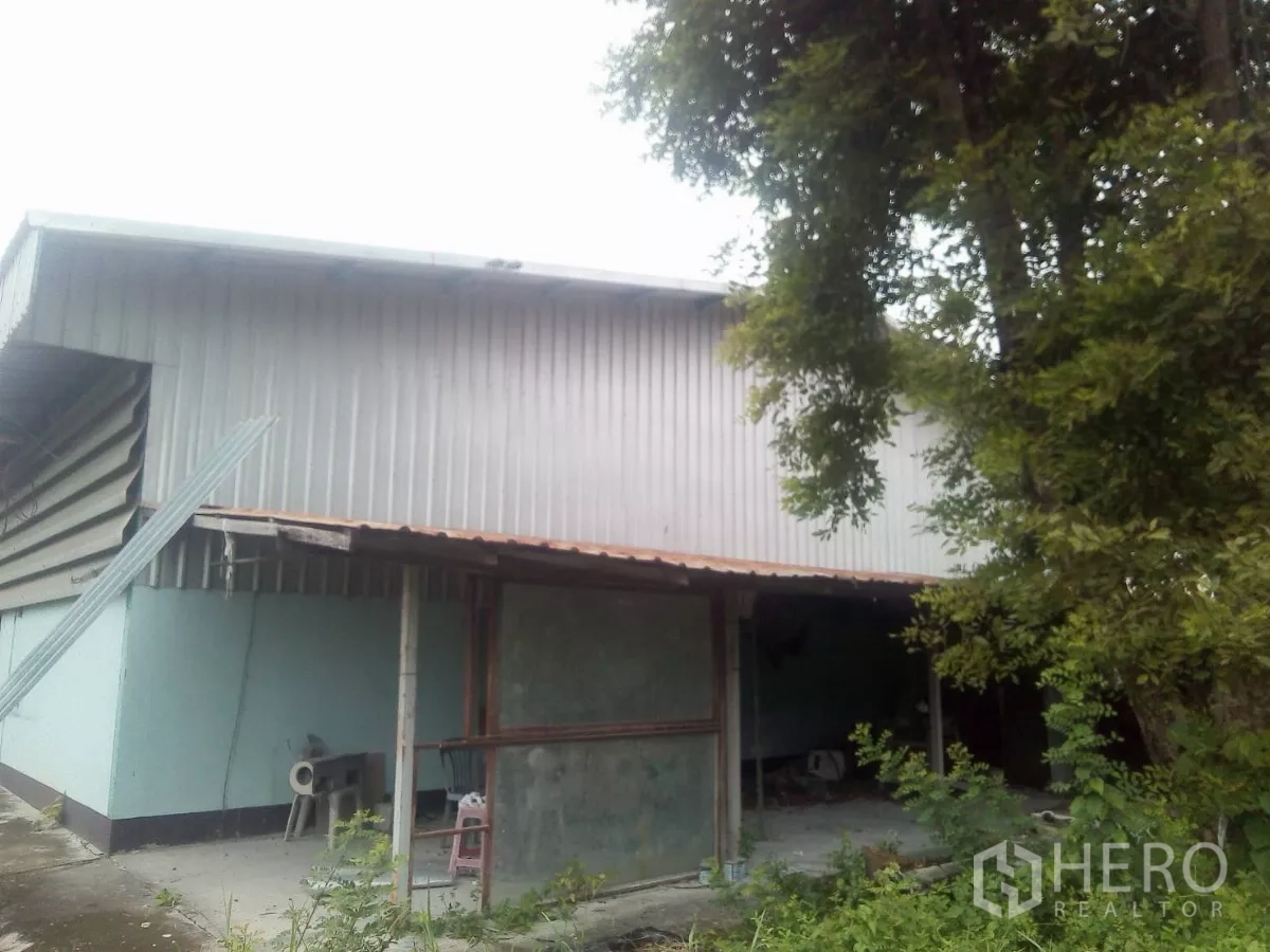ที่ดิน ขายในKhlong Sam Wa, Bangkok - ด้านนอกอาคารโกดังผนังเมทัลชีท ติดพื้นที่สีเขียวและลานคอนกรีตขนาดเล็ก