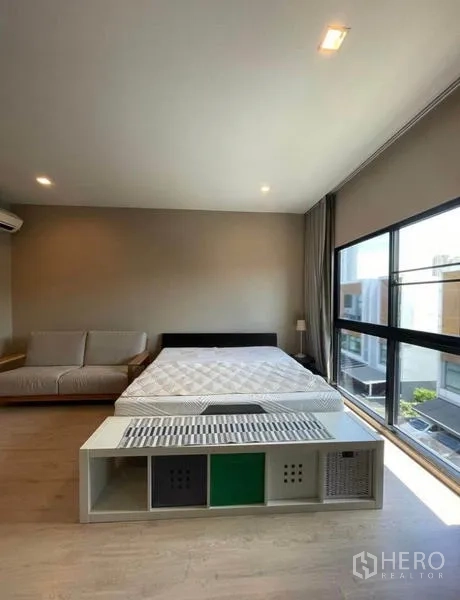 Townhouse for rent in Yan Nawa, Bangkok - Spacious master bedroom with sofa, king bed, and wide windows for natural light.
