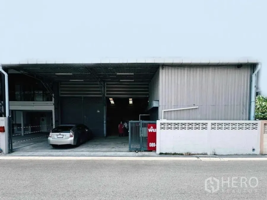 Warehouse for rent in Din Daeng, Bangkok - Steel-clad warehouse exterior with covered driveway, sliding gate and parking bay.