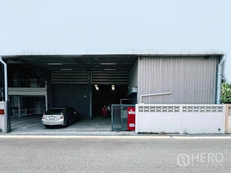 Warehouse for rent in Din Daeng, Bangkok - Steel-clad warehouse exterior with covered driveway, sliding gate and parking bay.