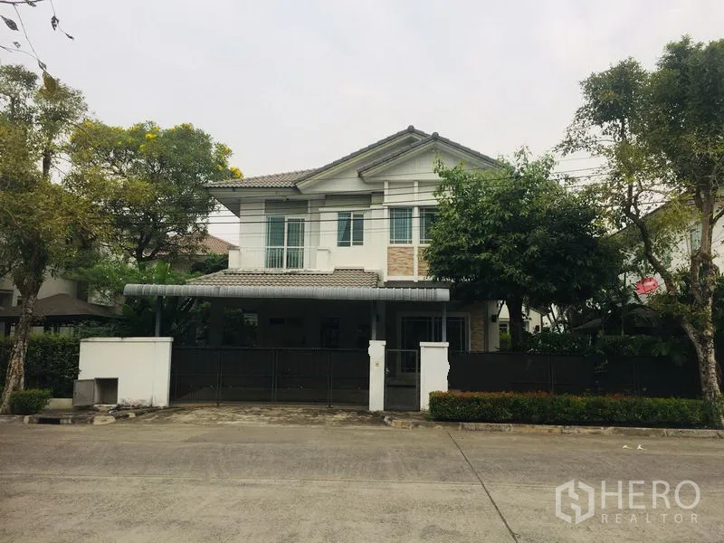 Detached House for rent in Bang Kapi, Bangkok - Two-storey detached house exterior with gated carport, front fence and mature trees in a quiet compound.