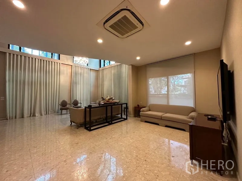 Detached House for rent or sale in Khan Na Yao, Bangkok - Expansive family room with high ceiling, marble flooring and large television.