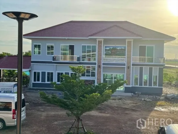 货栈 出租或出售在Pathum Thani - 两层现代住宅，带阳台与红色屋顶。