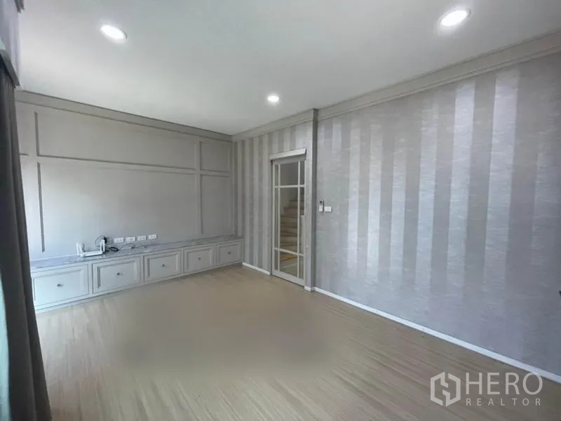 ทาวน์เฮาส์ ขายในSuan Luang, Bangkok - ห้องนั่งเล่นชั้นสอง ผนังลายทาง เคาน์เตอร์ทีวีบิวท์อิน และไฟดาวน์ไลท์