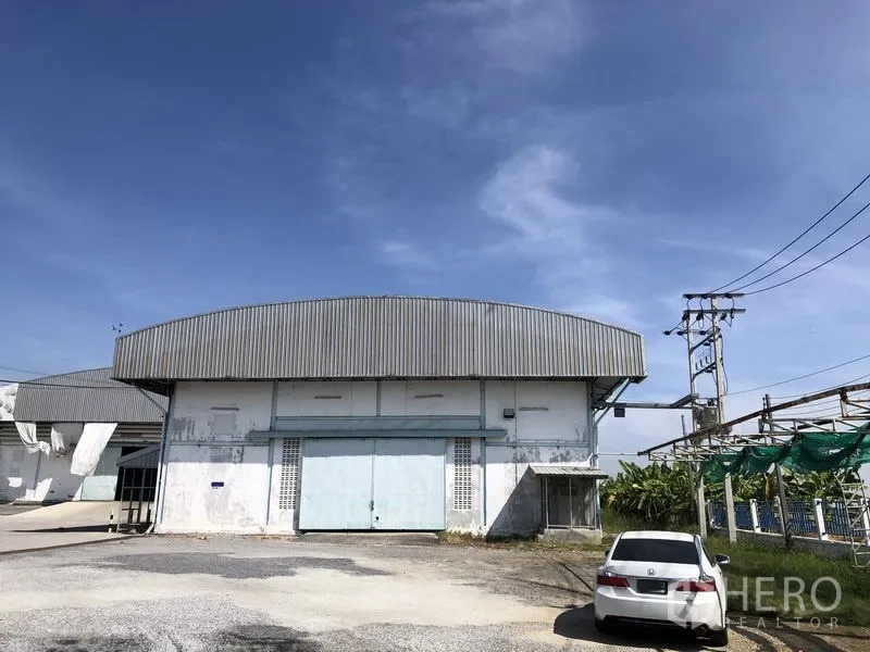 Warehouse for rent in Samut Prakan - Front exterior of a standalone warehouse with large sliding doors and parking in Bang Bo, Samut Prakan.