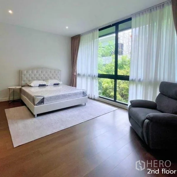 Detached House for rent in Bang Kapi, Bangkok - Spacious bedroom with large window, recliner and garden outlook.