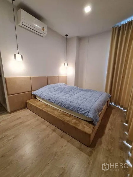 คอนโด ให้เช่า - ห้องนอนหลัก เตียงยกพื้น โคมไฟหัวเตียง เครื่องปรับอากาศ และผ้าม่านกันแสง