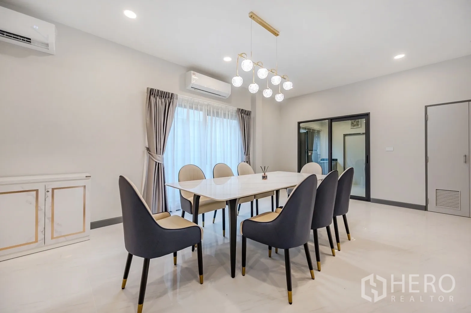 Detached House for rent in Bang Phli, Samut Prakan - Formal dining room for eight with modern chandelier and big windows