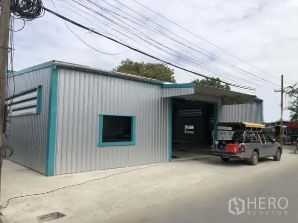 货栈 出租在Lak Si, Bangkok - 仓库转角视角，侧窗与带雨棚入口，靠近道路。