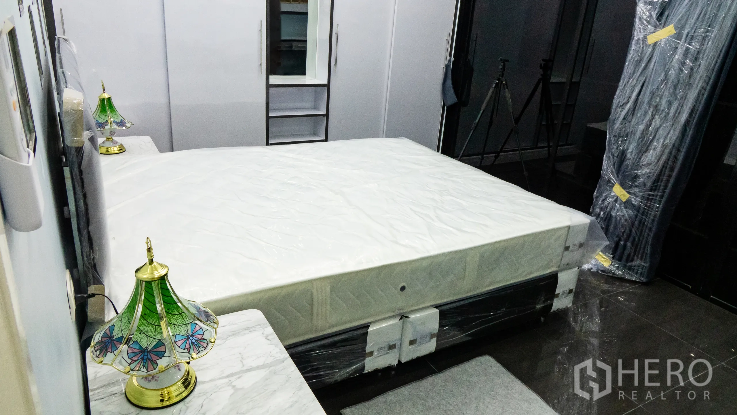 คอนโด for rent or sale in Khlong Toei, Bangkok - ห้องนอนพร้อมเตียงขนาดใหญ่ ตู้เสื้อผ้าไฮกลอสสีขาว และมุมโต๊ะเครื่องแป้งกระจก