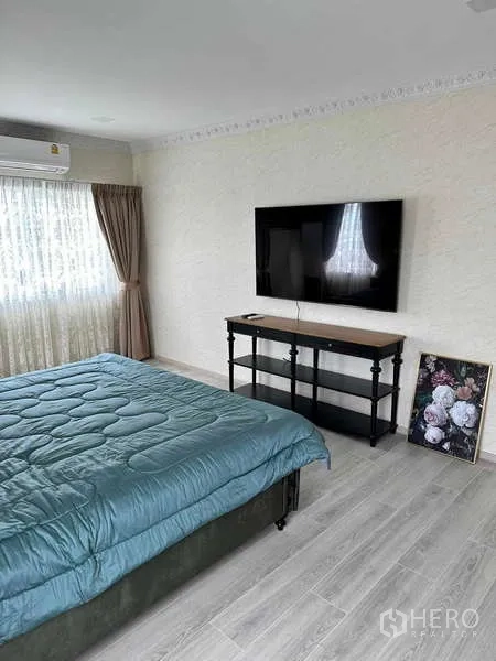Detached House for sale in Bang Phli, Samut Prakan - Master bedroom with TV mounted on wall and large window with drapes