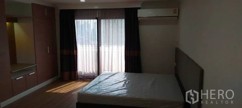 คอนโด ให้เช่าในWatthana, Bangkok - ห้องนอนมีประตูกระจกบานเลื่อนออกระเบียง ม่านทึบ ตู้เสื้อผ้าบิลต์อิน และโต๊ะเครื่องแป้ง