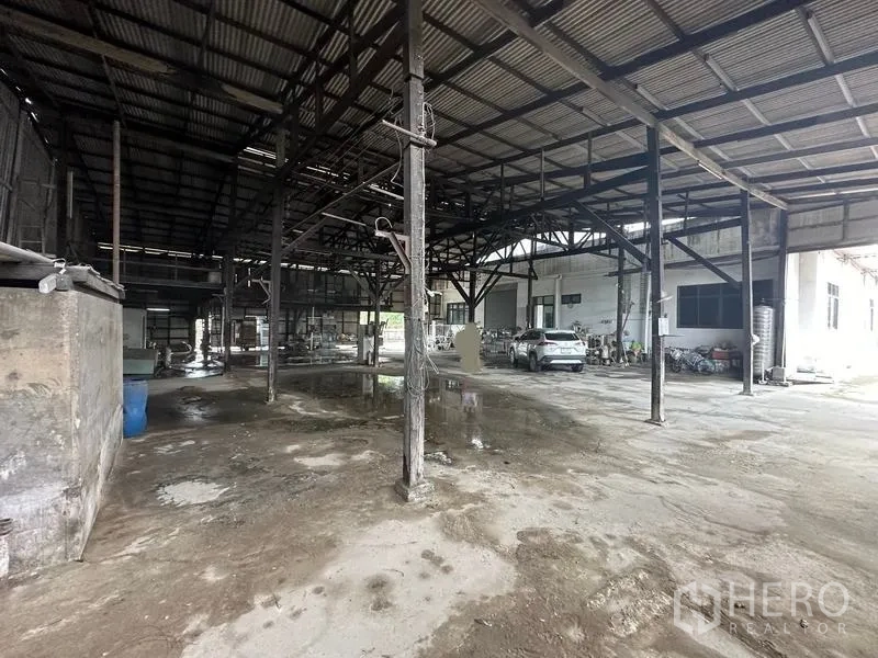 Home Office for sale in Phra Pradaeng, Samut Prakan - Warehouse interior with high steel trusses and open parking or work area.