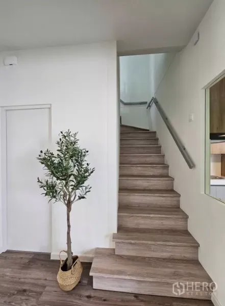 บ้าน ให้เช่าในBang Phli, Samut Prakan - บันไดไม้พร้อมราวจับมินิมอลและต้นไม้กระถางตกแต่ง