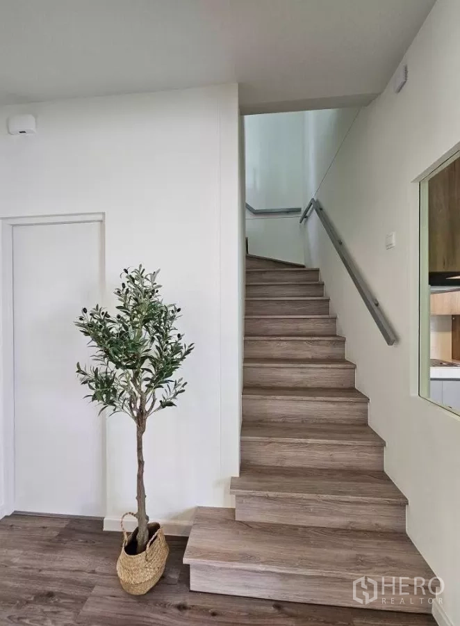 บ้าน ให้เช่าในBang Phli, Samut Prakan - บันไดไม้พร้อมราวจับมินิมอลและต้นไม้กระถางตกแต่ง