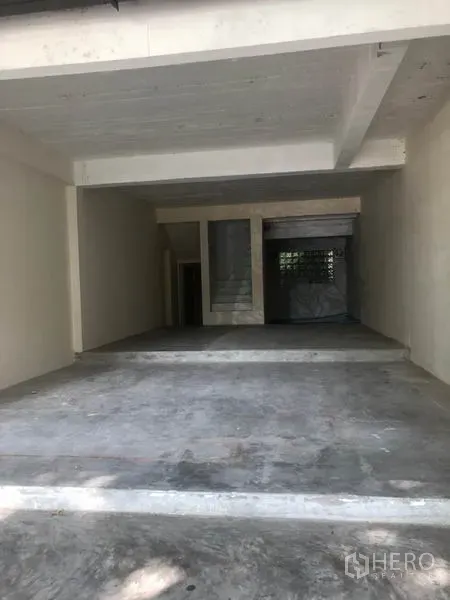 零售空间 出租在Watthana, Bangkok - 开放式室内毛坯，水泥地面、楼梯与后窗。