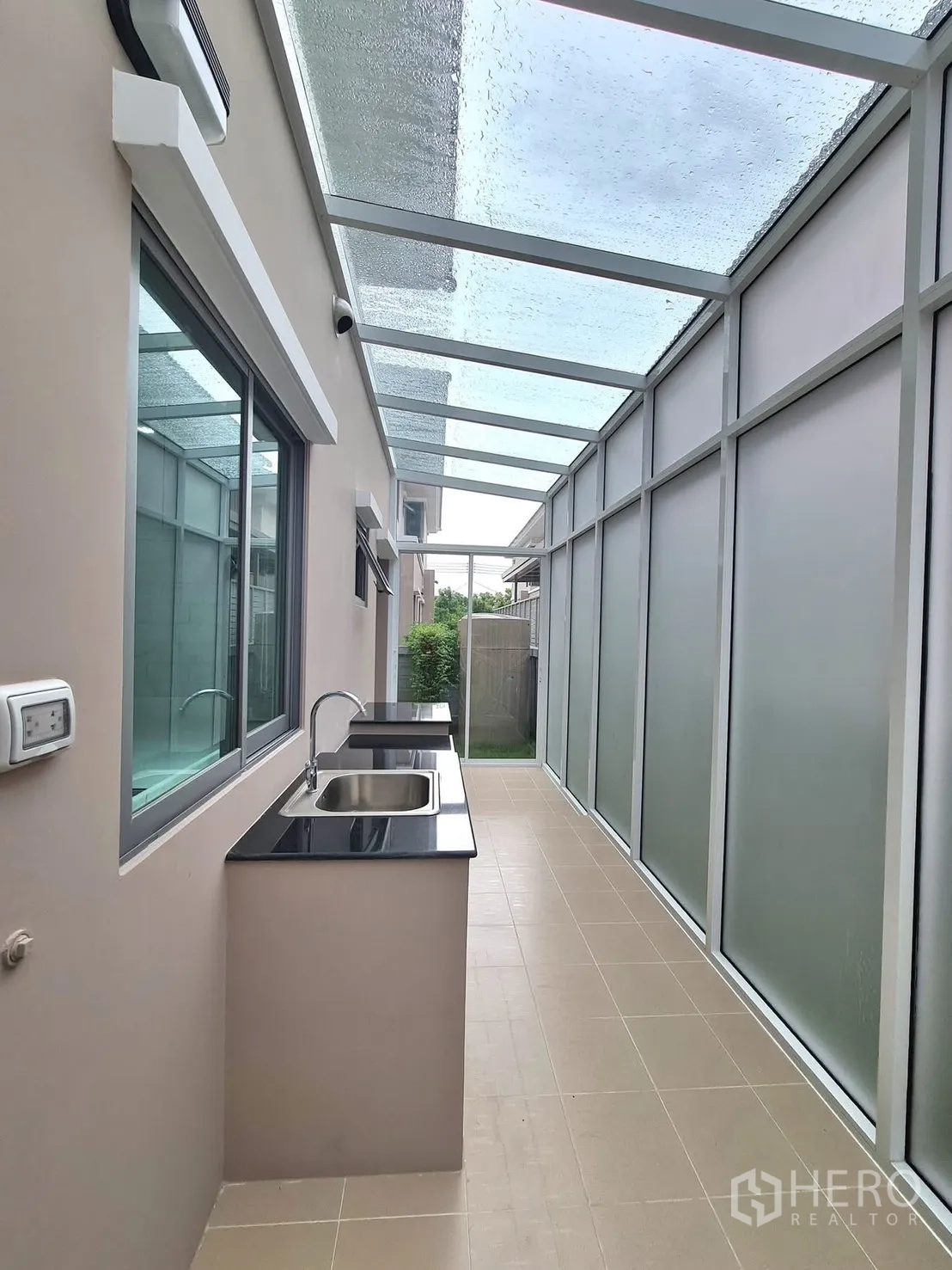 Detached House for rent in Lat Krabang, Bangkok - Covered outdoor kitchen with sink and black countertop.