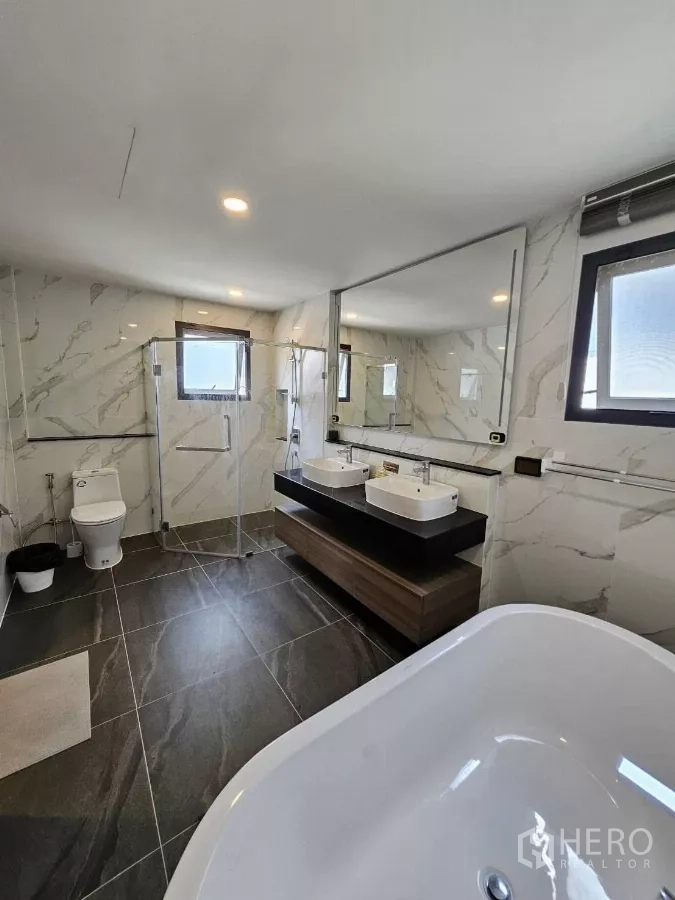 Detached House for rent or sale in Bang Phli, Samut Prakan - Luxury bathroom featuring freestanding tub, double vanity, frameless glass shower, and marble‑look walls.