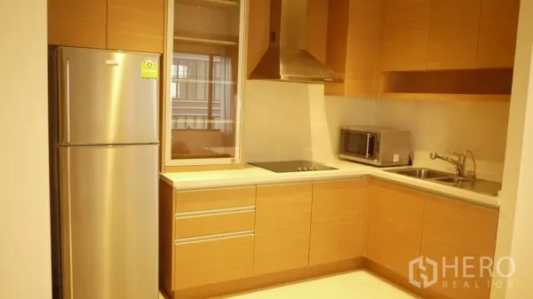 คอนโด ให้เช่าในKhlong Toei, Bangkok - ครัวรูปตัวแอล ตู้ไม้ เตาไฟฟ้า เครื่องดูดควัน ตู้เย็นสแตนเลส ไมโครเวฟ และอ่างล้างจาน