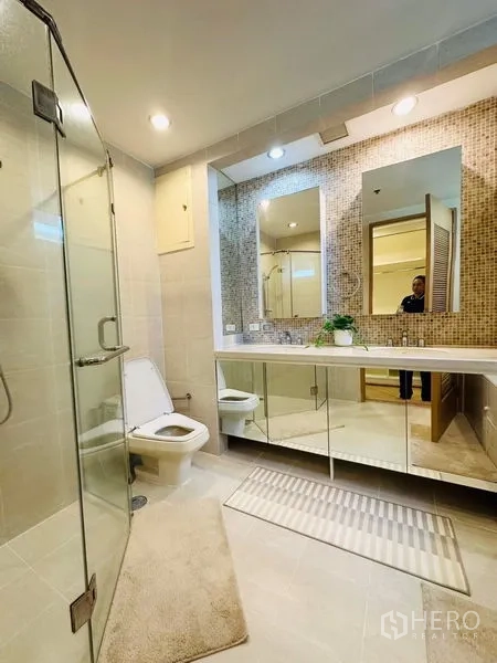 公寓 出租在Bang Rak, Bangkok - 宽敞卫浴，玻璃淋浴间、长台面、马赛克背景墙与镜柜。