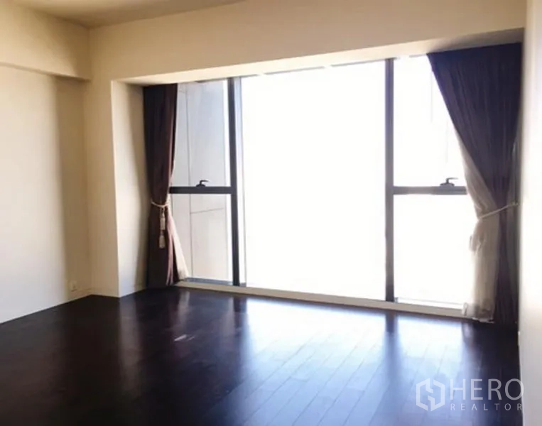 公寓 出租或出售在Sathon, Bangkok - 卧室配深色木地板与大落地窗及窗帘。