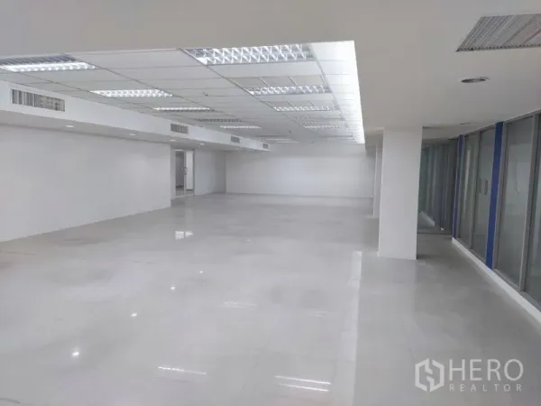 Office Space for rent in Chatuchak, Bangkok - Light-filled open-plan office with suspended ceiling lights and windows along the side.