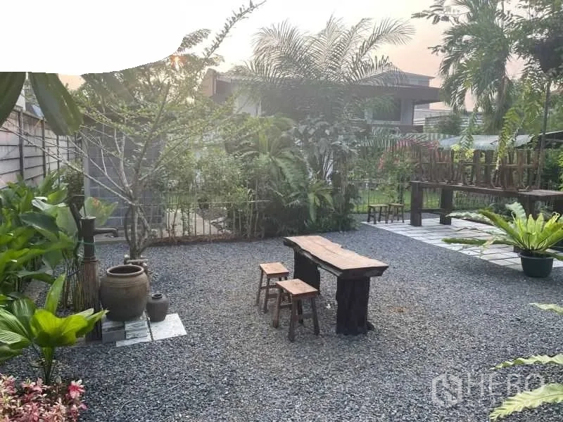 พื้นที่ขายปลีก ให้เช่าในSuan Luang, Bangkok - ลานกรวดพร้อมชุดโต๊ะม้านั่งไม้และพรรณไม้เขียวขจีในยามเช้า