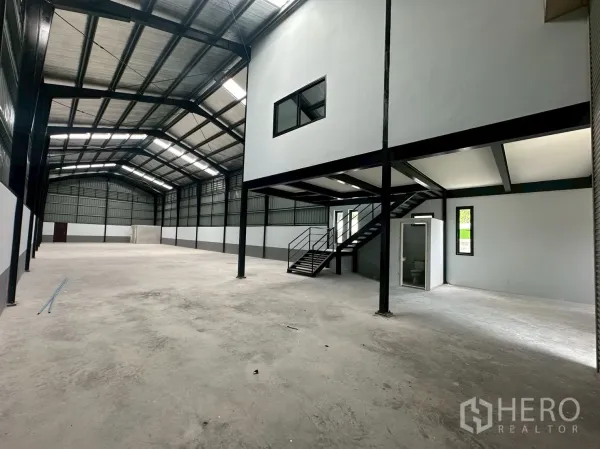 Warehouse for rent in Suan Luang, Bangkok - Large warehouse hall with high ceiling, staircase to office mezzanine and restroom.
