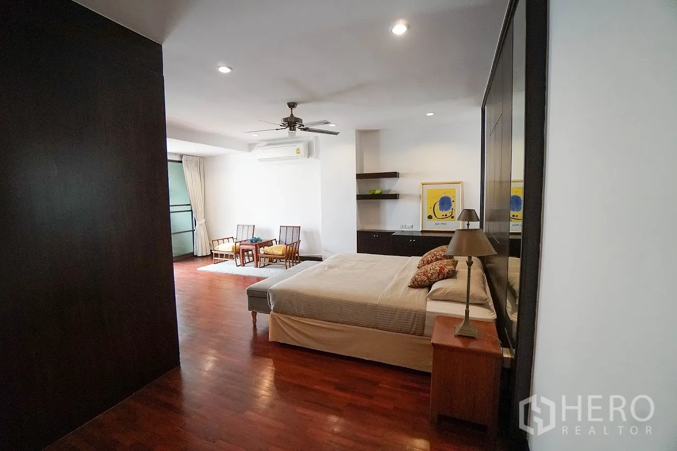 房间 出租在Watthana, Bangkok - 主卧配休闲区，木地板与吊扇，特大床。