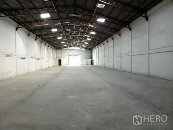 货栈 出租在Khlong Toei, Bangkok - 长跨仓库大厅，照明明亮，混凝土地坪，尽头设有装卸卷闸门。