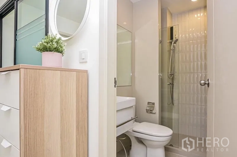 คอนโด ให้เช่าในDin Daeng, Bangkok - ห้องน้ำในตัวขนาดกะทัดรัด มีโถสุขภัณฑ์ อ่างล้างหน้า และตู้ shower กระจก ข้างตู้ลิ้นชัก