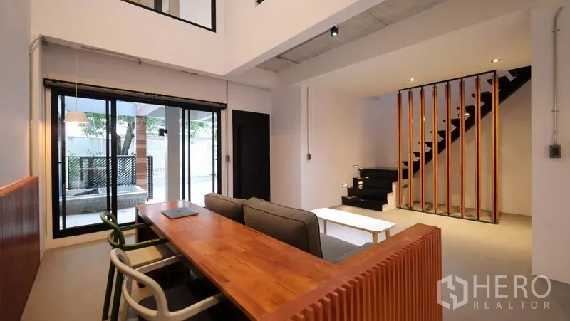 ทาวน์เฮาส์ ให้เช่าในKhlong Toei, Bangkok - ห้องนั่งเล่นโอเพ่นแปลน บันไดลอยและประตูกระจกสู่เฉลียง