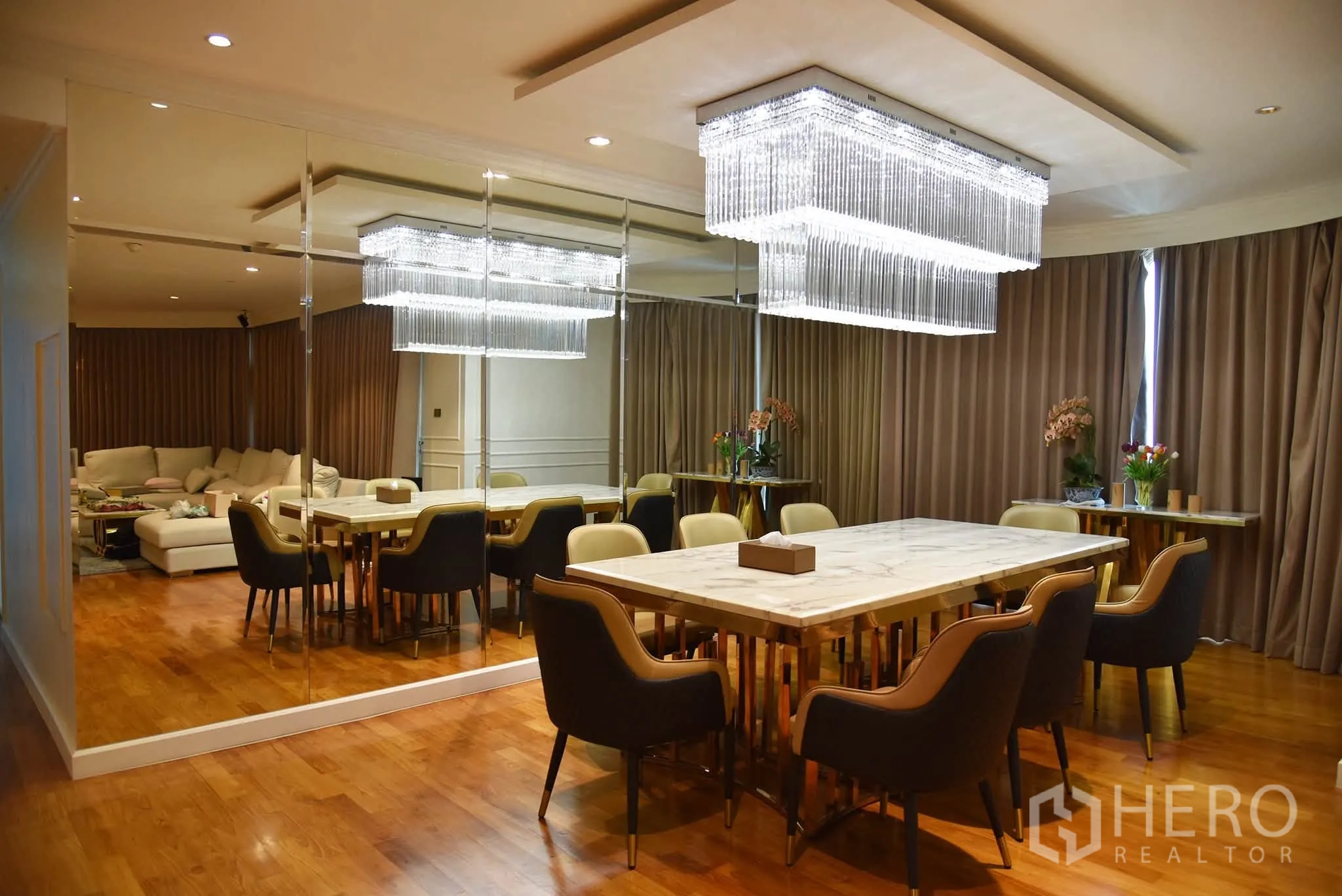 Condominium for sale in Khlong San, Bangkok - Elegant dining area with a marble table, upholstered chairs, and crystal chandeliers.