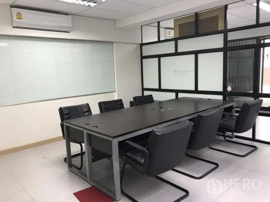 Office Space for rent in Khlong Toei, Bangkok - Conference room with long table, leather chairs, glass partitions and wall whiteboard in a Bangkok office.