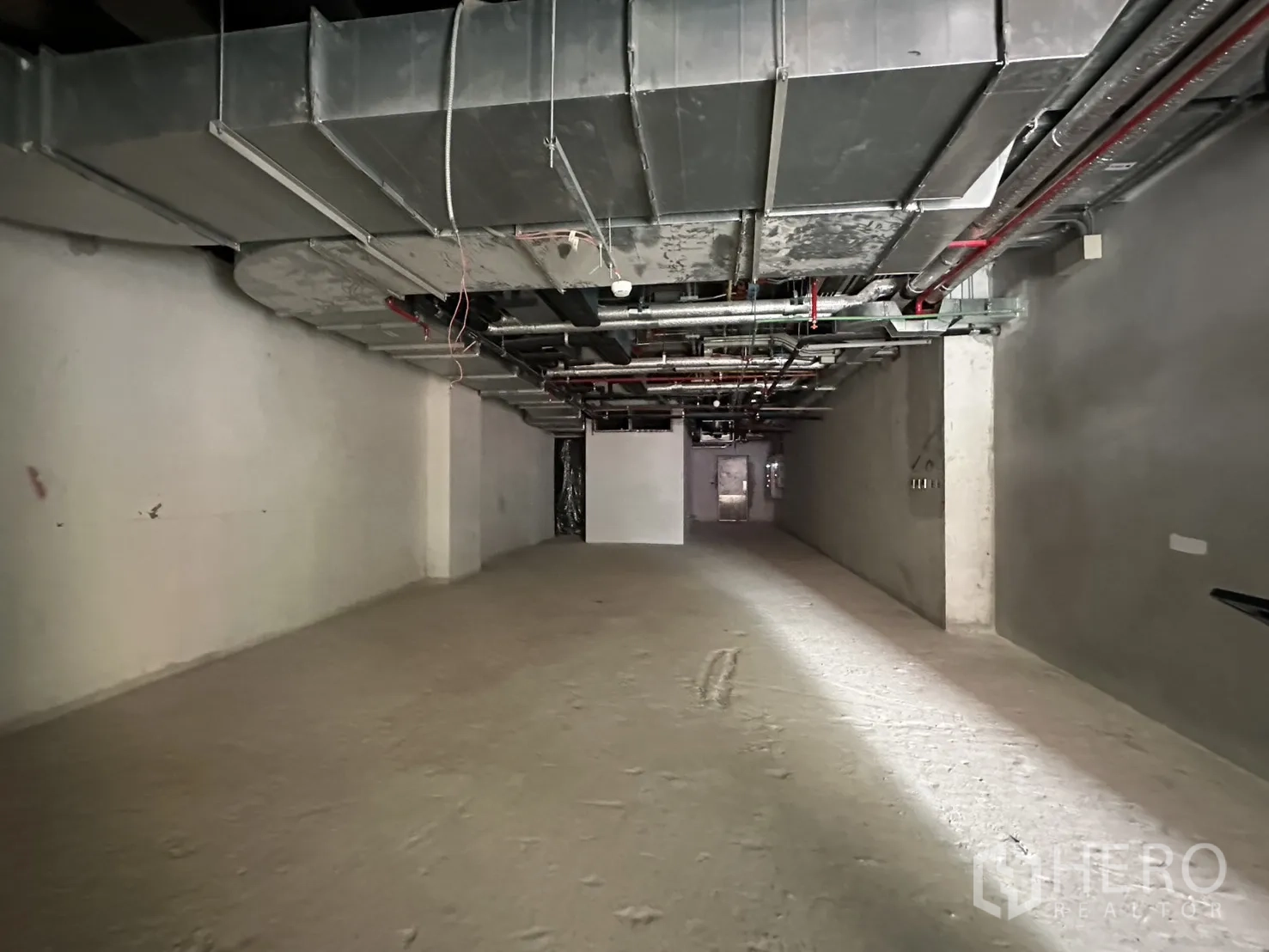 零售空间 for rent in Bang Rak, Bangkok - 长进深开间零售内部，未完成墙面并可见风管与管线。