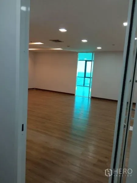 办公空间 出租在Huai Khwang, Bangkok - 空置办公室，木地板、嵌入式照明，玻璃门通向采光区。