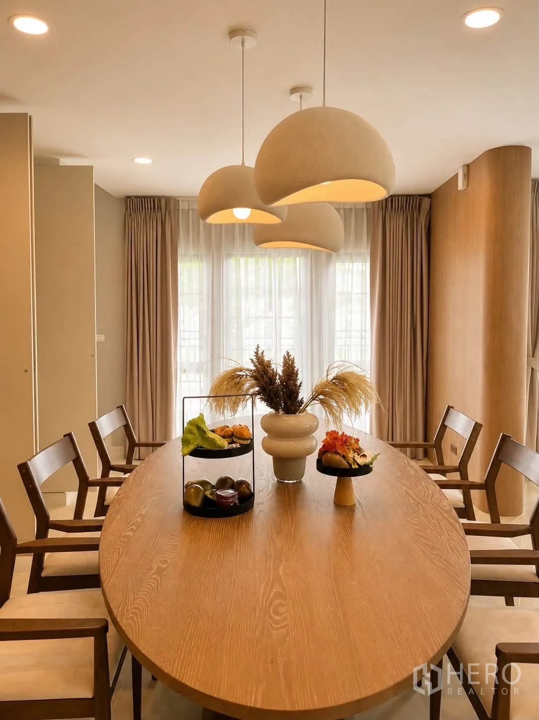 独栋房屋 for rent in Bang Phli, Samut Prakan - 餐厅配椭圆形木桌、吊灯与纱帘。
