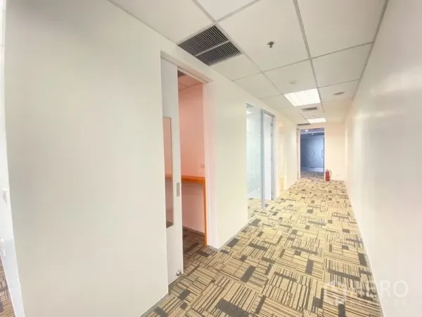 办公空间 出租在Chatuchak, Bangkok - 明亮走廊，铺地毯，带推拉门与玻璃隔断的现代办公室