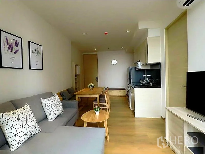 คอนโด ให้เช่าในKhlong Toei, Bangkok - ห้องนั่งเล่นโปร่งสว่าง โซฟาสีเทา โต๊ะทานข้าว และครัวบิวท์อินสไตล์โมเดิร์น