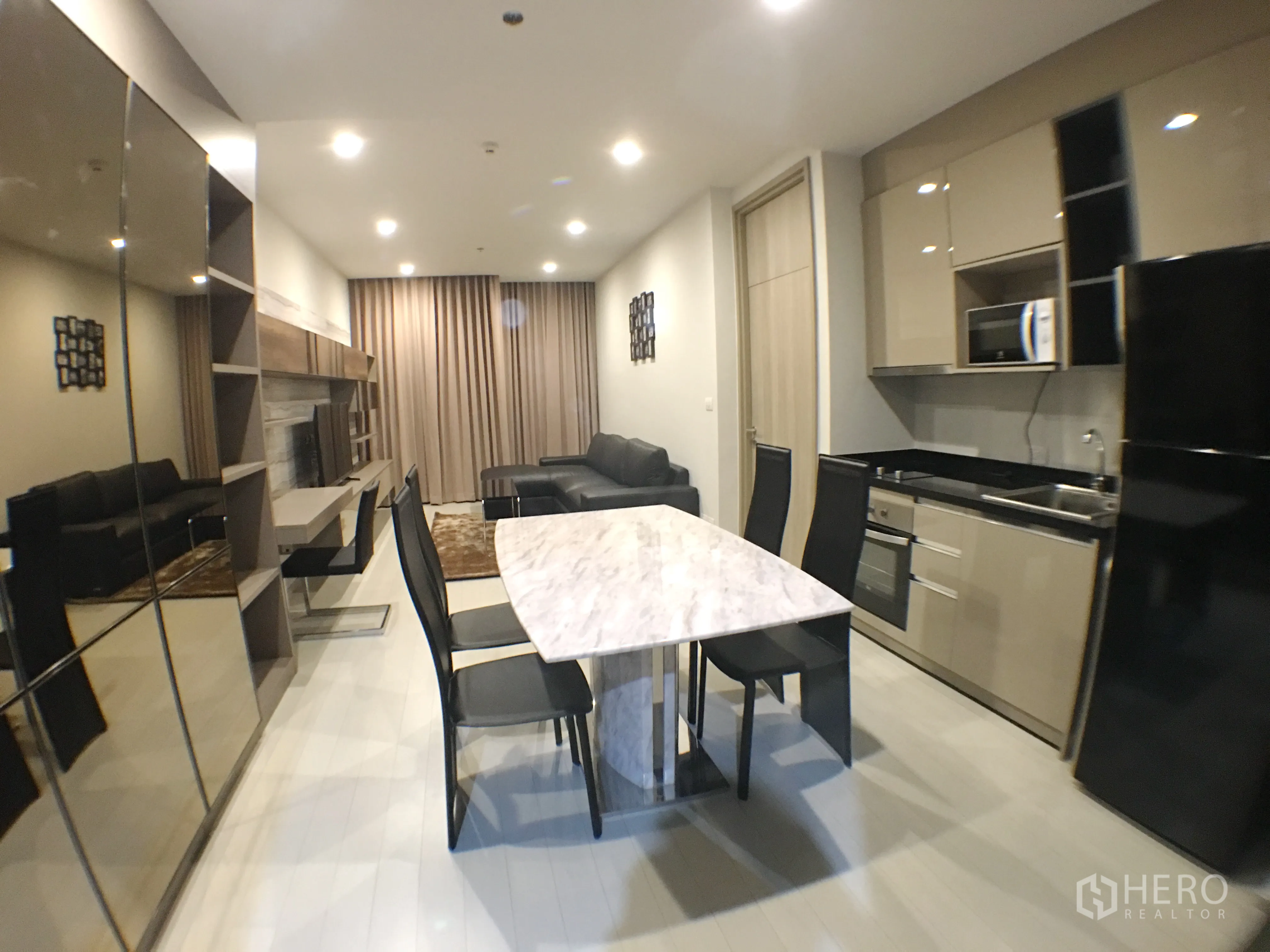 Condominium for rent in Pathum Wan, Bangkok - Sleek kitchen and dining area with marble table, full appliances and ample storage.