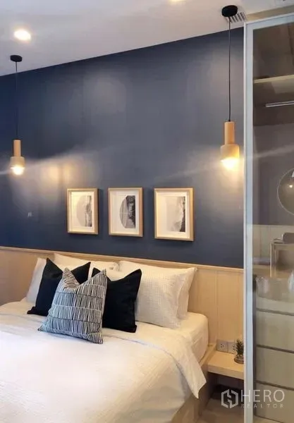 คอนโด ให้เช่าในWatthana, Bangkok - ห้องนอนมีไฟห้อยข้างเตียง งานศิลป์ติดผนัง และตู้บิวท์อินชิดผนังสีน้ำเงิน