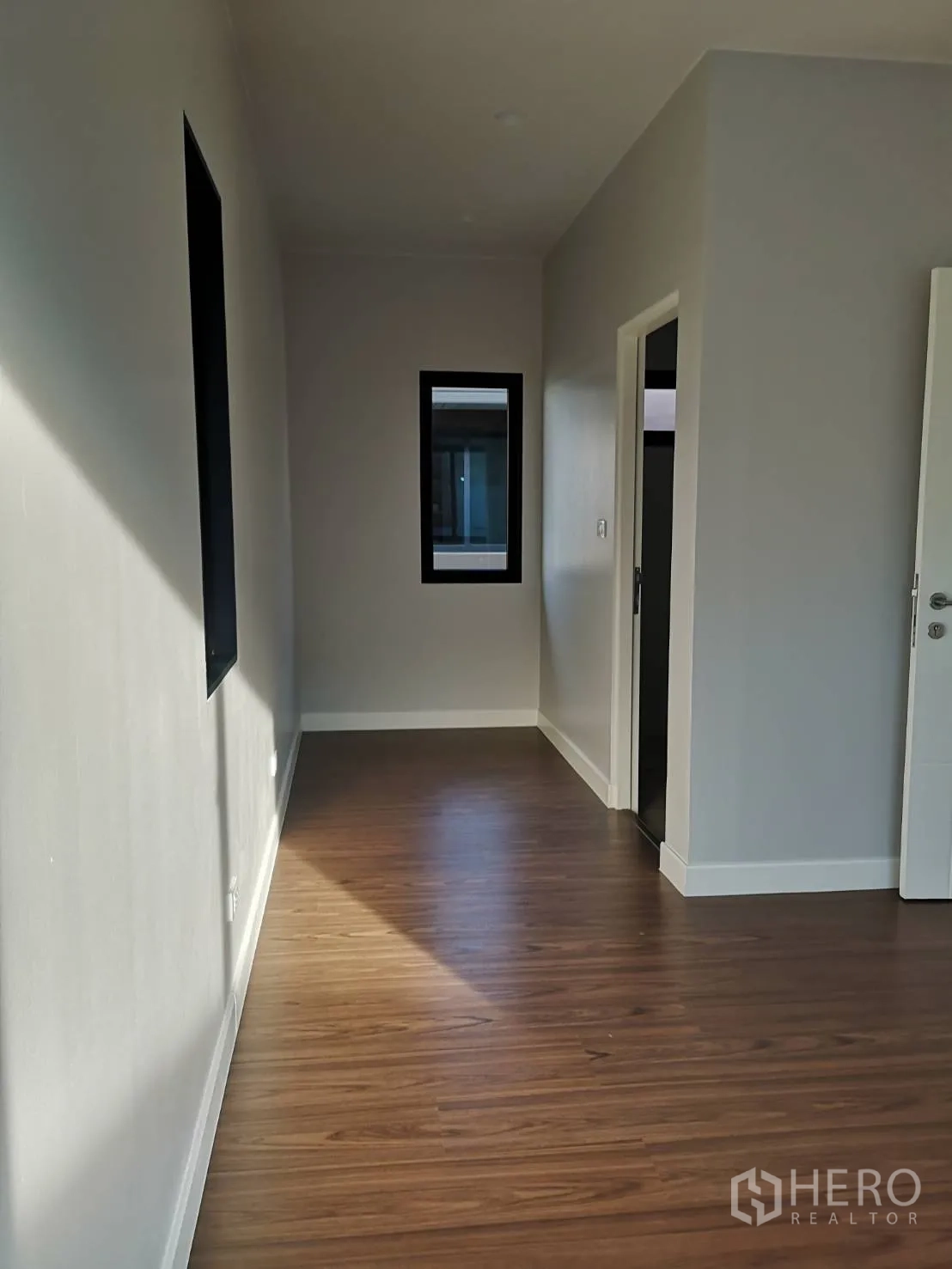 บ้าน ขายในLam Luk Ka, Pathum Thani - โถงชั้นบน พื้นลายไม้ พร้อมหน้าต่างกรอบดำเชื่อมสู่ห้องนอน