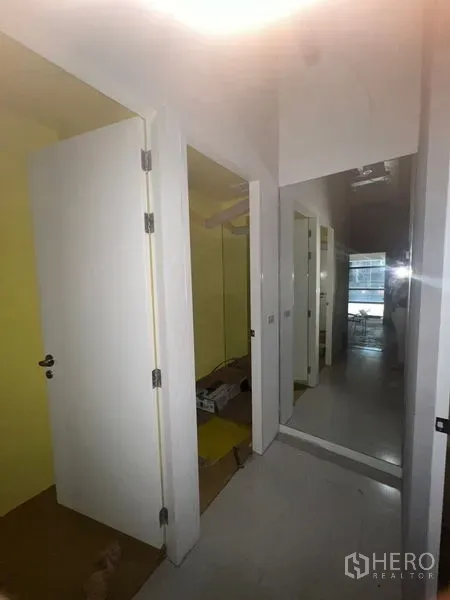 零售空间 出租在Watthana, Bangkok - 后勤走廊，白色门与通顶镜面，适合作为员工或试衣区。