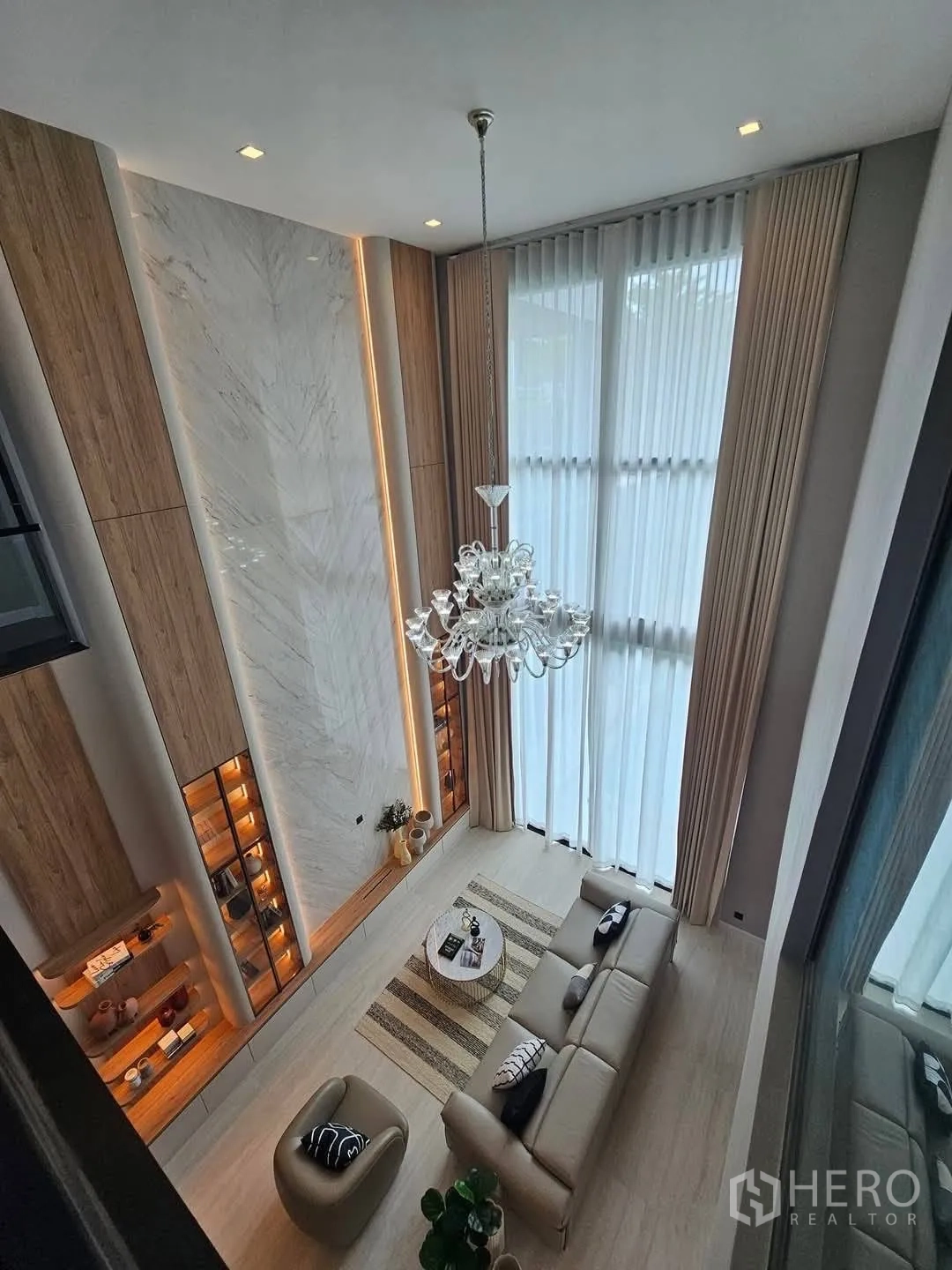 Detached House for rent or sale in Suan Luang, Bangkok - Aerial view of double-volume lounge with chandelier and large windows.