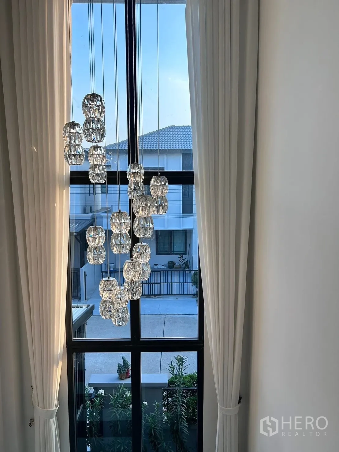 Semi-detached House for rent in Bang Phli, Samut Prakan - Double-height window with cascading crystal chandelier overlooking the neighborhood.