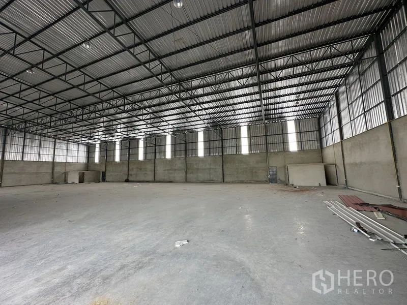 Warehouse for rent in Lam Luk Ka, Pathum Thani - Clear-span warehouse interior with vertical translucent panels and smooth concrete slab.